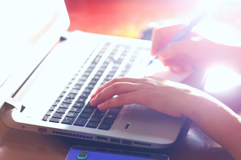 A hand typing on a laptop keyboard